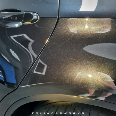 Schwarze Autoflackern mit Lichtreflexionen und sanften Kratzern.