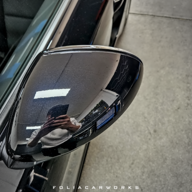 Schwarzer Außenspiegel mit Spiegelreflexion in der Oberfläche.